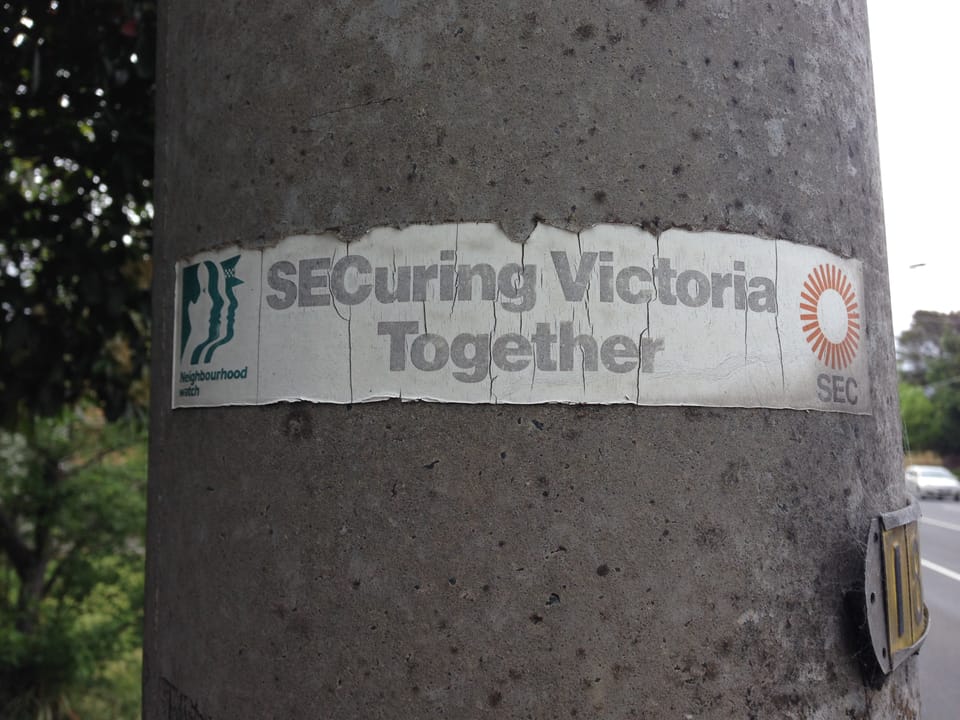 Photo of an old sticker on a concrete power pole that reads "SECuring Victoria Together" with the SEC logo to the right.