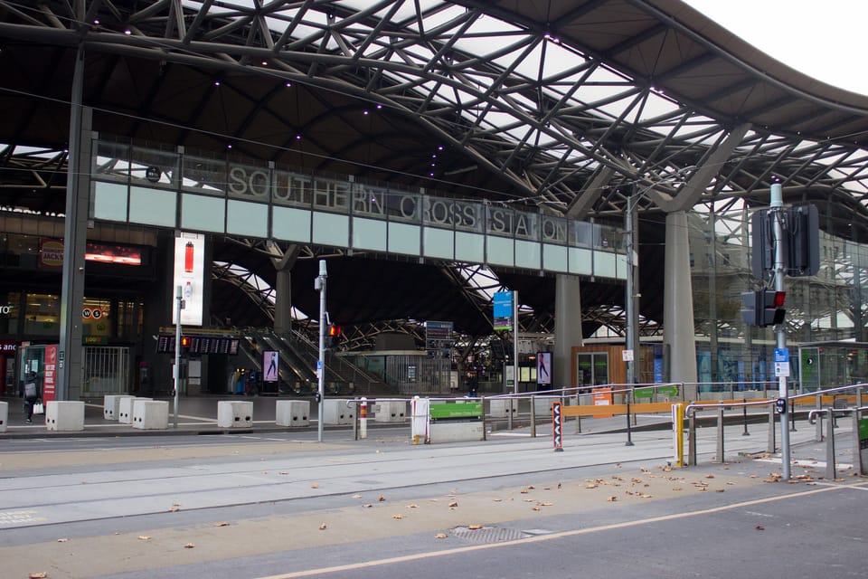 A photo of the front entrance to Southern Cross Station on Spencer Street and Collins Street next to a tram stop.